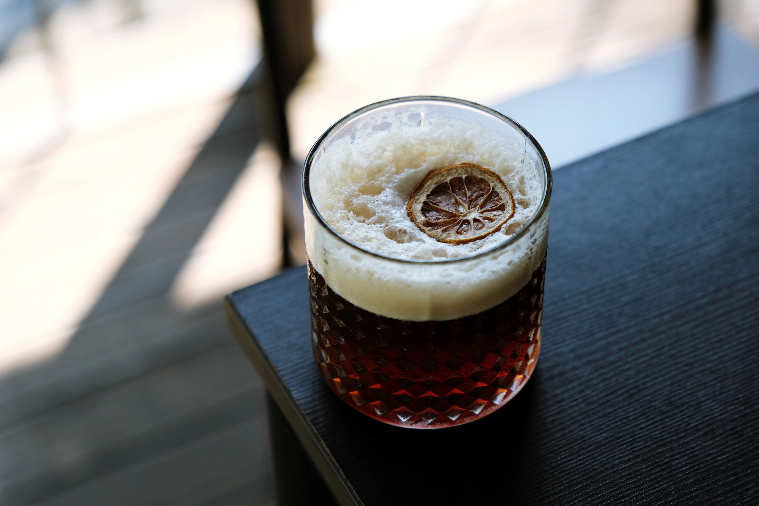 Foamy espresso tonic drink on a wooden table